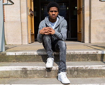 Young man sits on steps 