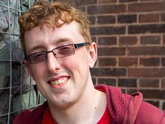 Young man smiles for portrait outside