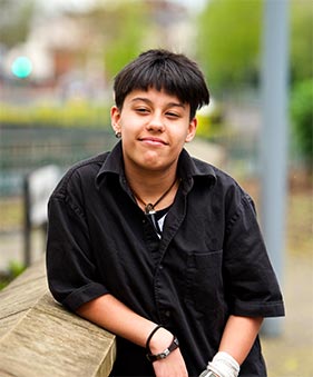 Young person poses for photograph outside